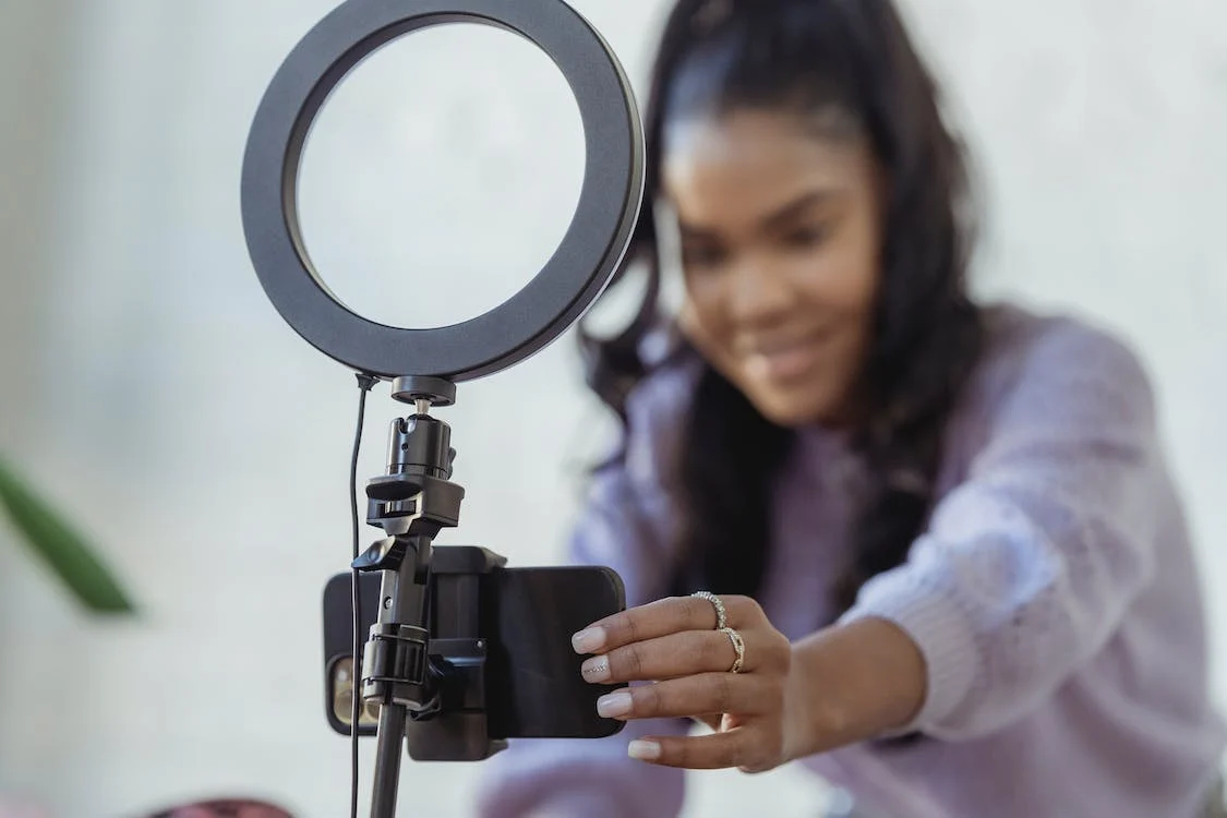 woman setting up phone camera with ring light